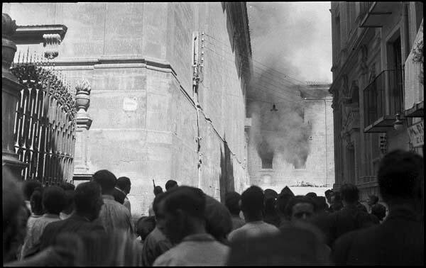 Untitled (Onlookers watch as a building adjacent to the Cathedral is set on fire)