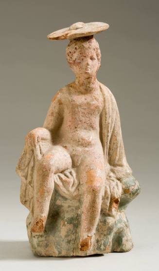 Tanagra figurine of a seated man
