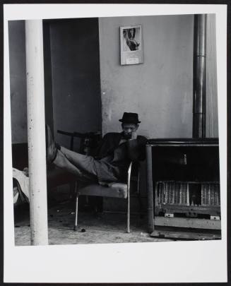 Man with feet on pole, from the series "East Side"