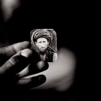 Abdul Aziz holding a photograph of his brother, Mula Abdul Hakim, Afghan refugee village, Khairabad, north Pakistan